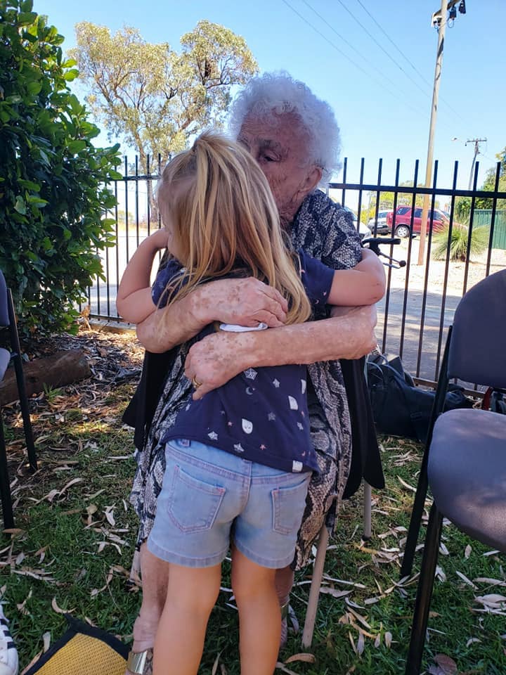 Senior Cuddling Young Girl