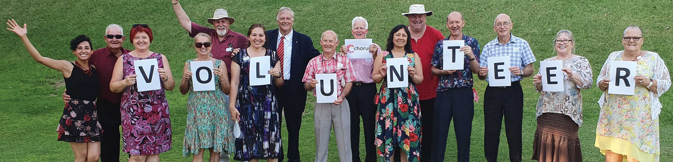A photograph of volunteers holding up giant letters to form the word "volunteering"