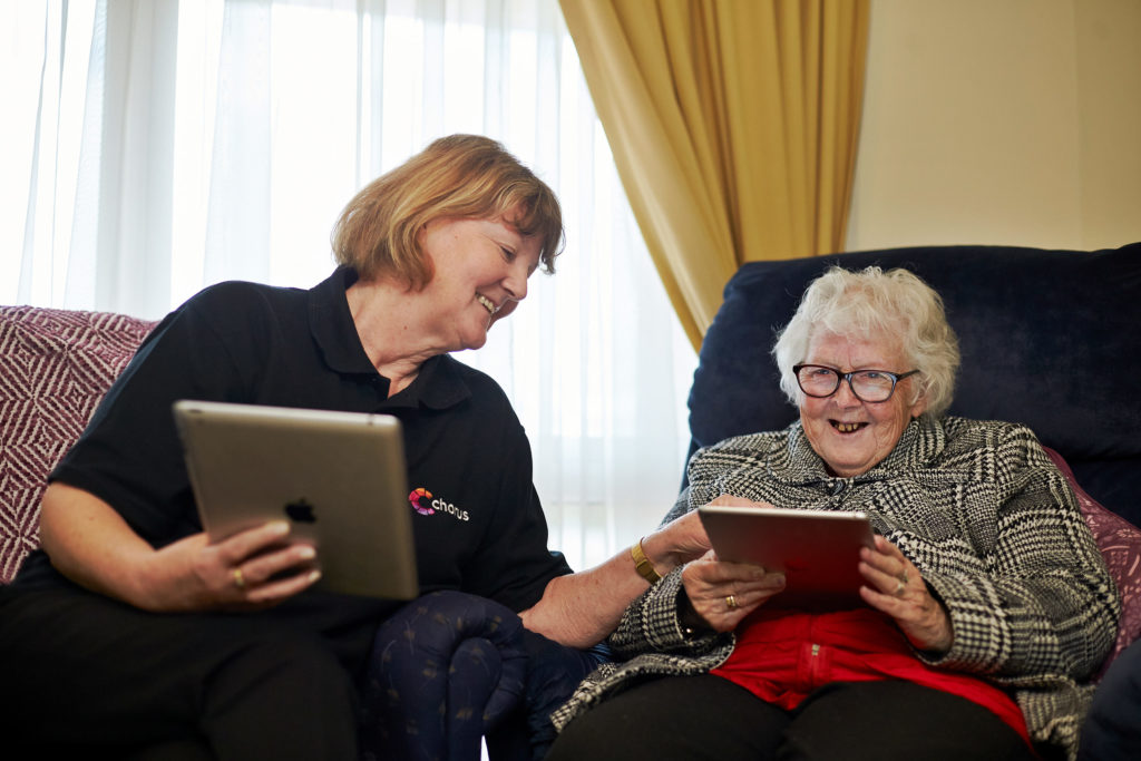 Chorus staff member helping older lady with iPad