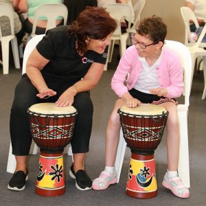 Chorus staff drumming with customer 