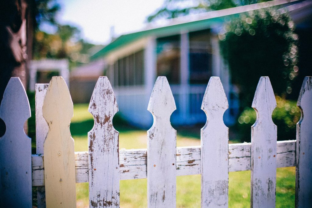 Overlooking a picket fence into a neighbour’s yard, symbolising the sense of neighbourliness and community micro-volunteering can create.