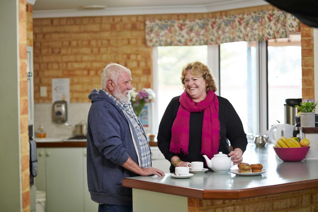 older man having tea and chat with younger lady