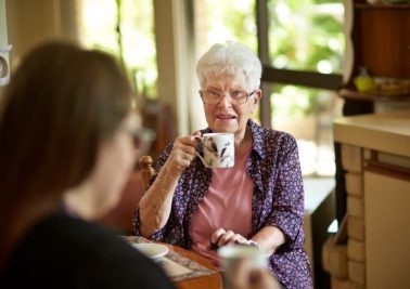 Support worker with customer having tea