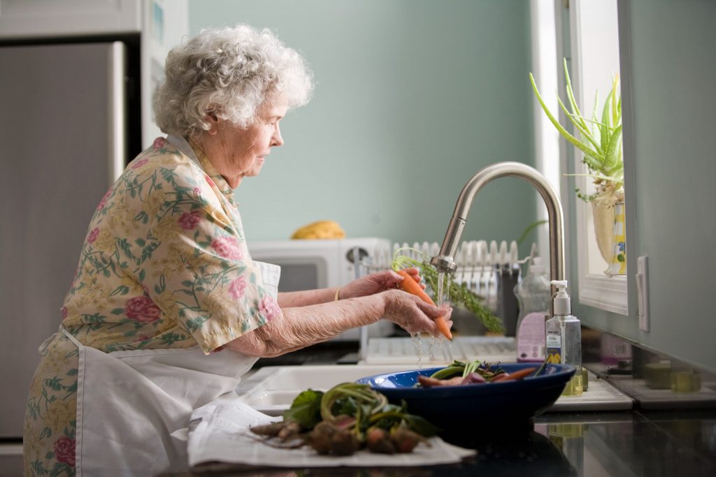 Image of older person washing vegetables