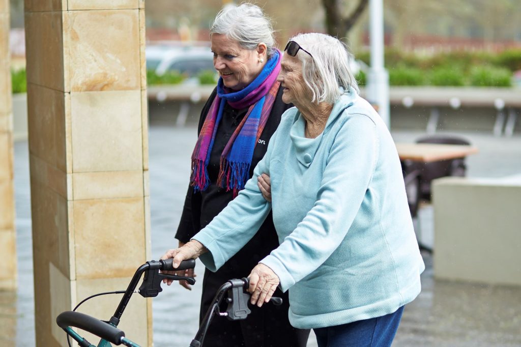 support worker walking with customer using a walker