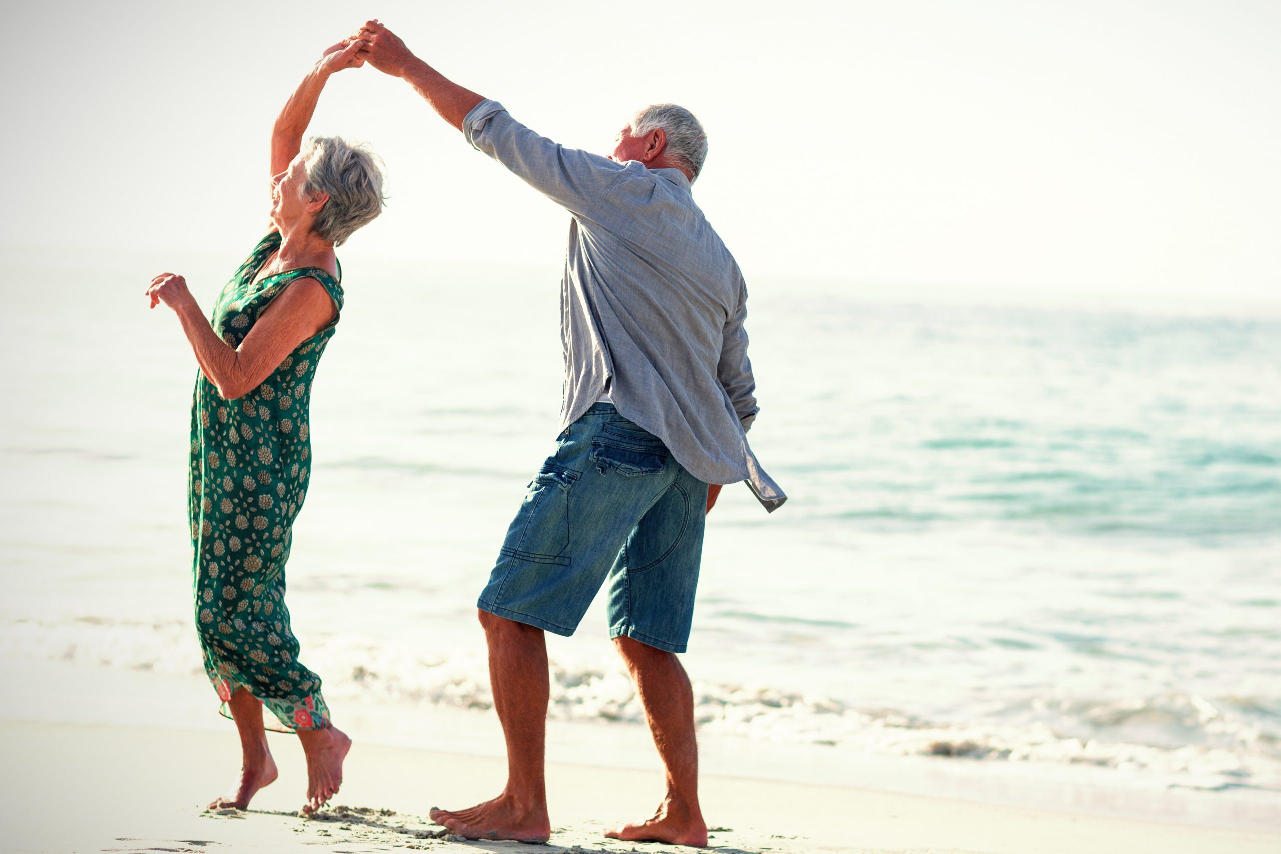 older couple exercising on beach